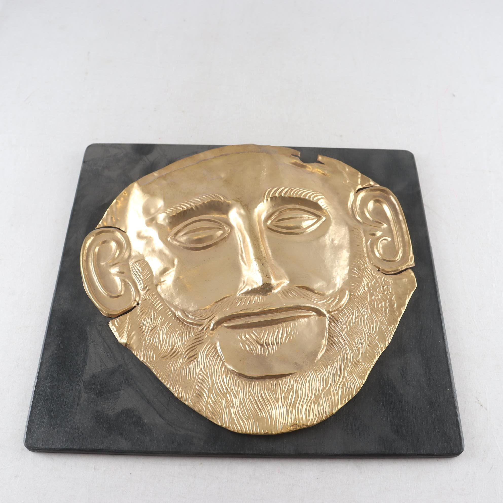 Väggrelief, förgylld plåt, kopia av Agamemnons dödsmask. Samfraktas ej.