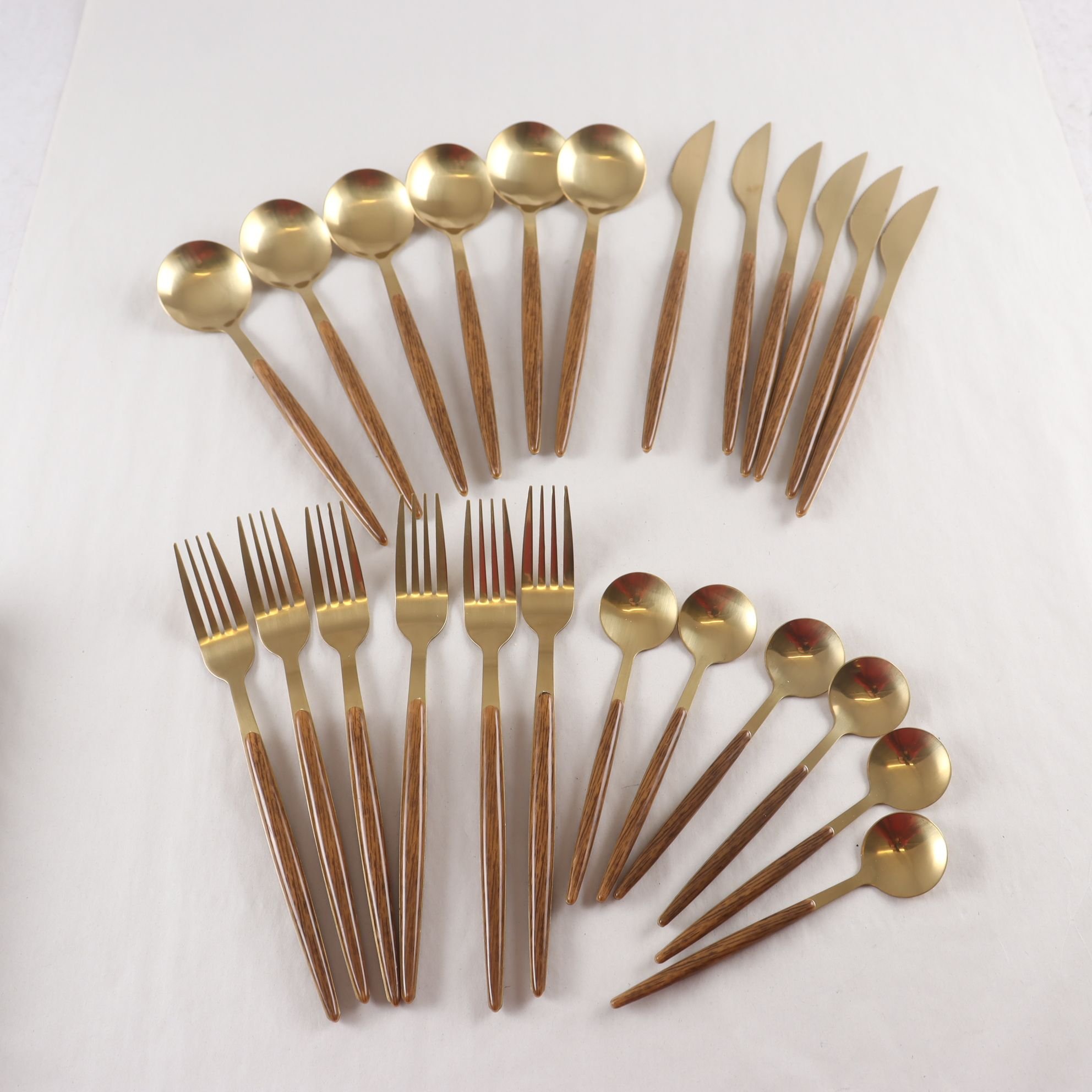 Bestick, guldfärgad metall, träimitation i plast